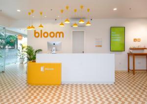 a lobby of a bloom office with a yellow and white counter at Bloom Hotel - Brookefield in Bangalore