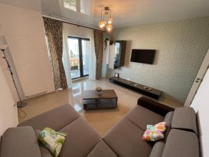 a living room with a couch and a tv at Mamaia Beach LuxyMar 3 Apartment in Mamaia