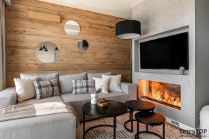 sala de estar con sofá y chimenea en TatryTop Apartamenty przy stoku Białka Ski, en Białka Tatrzanska