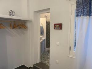 baño con pasillo con lavabo y espejo en Ονειρόπετρα Λέρος~Oneiropetra Leros, en Panteli