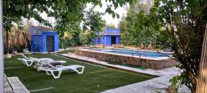 - une piscine avec 2 chaises et une table dans l'établissement Casa De Campo Azul En Antequera, à Antequera