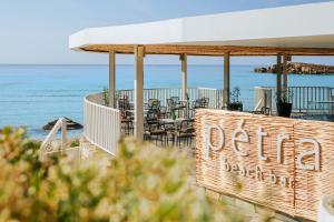 a restaurant with tables and chairs on the beach at Nissi Beach Resort in Ayia Napa