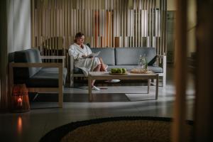 a woman sitting on a couch in a living room at Nissi Beach Resort in Ayia Napa
