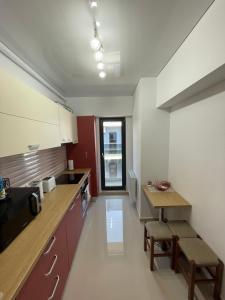uma cozinha com armários vermelhos e brancos e uma mesa em Mamaia Beach LuxyMar 3 Apartment em Mamaia