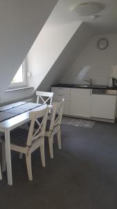 a dining room with a table and chairs and a kitchen at Ferienwohnung Höchberg in Höchberg