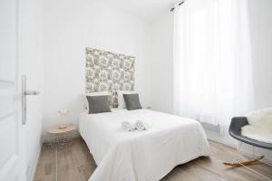 a white bedroom with a bed with two towels on it at Le Concorde 2 Calanques Vélodrome JO24- MaisonMars in Marseille