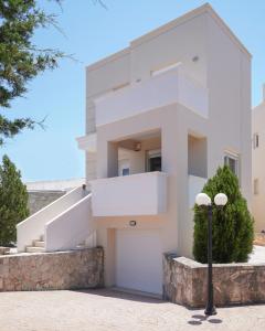 ein weißes Haus mit einer Treppe und einer Garage in der Unterkunft Hestia Maisonette in Arónion
