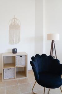 een woonkamer met een blauwe stoel en een tafel bij Hestia Maisonette in Arónion