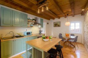 a kitchen with green cabinets and a wooden table at Guest House Eleonora in Čabrunići