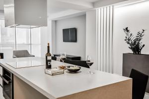 a kitchen with a white counter with two glasses of wine at HO By Olivencia Paseo de Almeria 45 in Almería