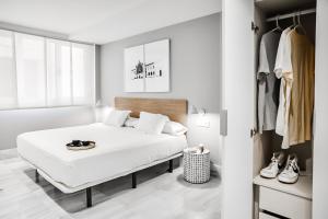 a white bedroom with a bed and a closet at HO By Olivencia Paseo de Almeria 45 in Almería