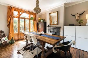 uma sala de jantar com uma mesa de madeira e cadeiras em Beautiful 3BD Home Forest Hill South London em Londres