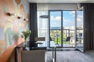 a dining room with a table and a large window at Sea Premium Aparthotel in Gdynia