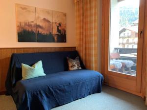 a blue couch in a room with a window at Ski und Therme 2 in Bad Kleinkirchheim