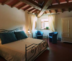 a bedroom with a bed and two blue chairs at Palagina la dimora in Figline Valdarno