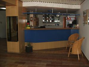 a bar with two chairs and a blue wall at Hotel Sport in Jablonec nad Nisou