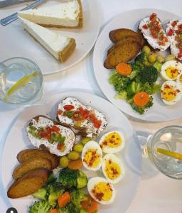 drie borden eten op een tafel met eieren en groenten bij South Hotel in Tasjkent