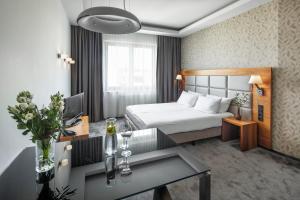 グディニャにあるSea Premium Apartmentsのベッドとテーブルが備わるホテルルームです。