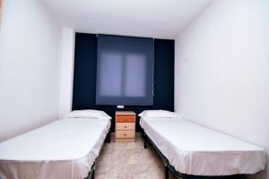 2 camas en una habitación con una pantalla grande en Bahia, en La Pineda
