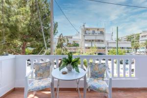 a white balcony with a table and two chairs at Modern Escape Near Riviera & Niarchos Foundation! in Athens