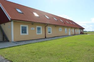 a row of buildings with windows and a grass field at Kärraton Vandrarhem in Åhus