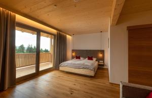 a bedroom with a bed and a large window at Pircherhof - Adults Only am Bauernhof in Pöllau