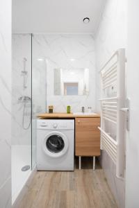 W białej łazience znajduje się pralka. w obiekcie Le Concorde 3 - Appartement 2 chambres - 8 pers - Terrasse - Clim w Marsylii