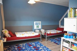 een kamer met 2 bedden en een boekenplank bij Ferienhaus _Hasenland_ in Kerkwitz