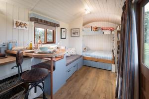 a small room with a table and a bed at Cow Parsley Shepherd's Hut in Berwick-Upon-Tweed