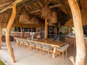 ein Esszimmer mit einem großen Holztisch und Stühlen in der Unterkunft Kazondwe Camp and Lodge in Kongola