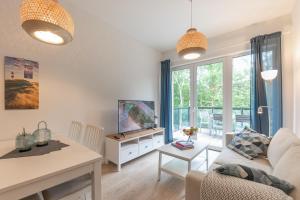 ein Wohnzimmer mit einem Sofa und einem TV in der Unterkunft Wohnen am Südstrand - Ferienwohnung 1 5 in Wyk auf Föhr