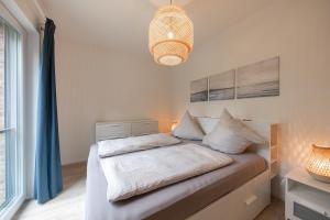 a bedroom with a bed with a blue curtain at Wohnen am Südstrand - Ferienwohnung 1 5 in Wyk auf Föhr