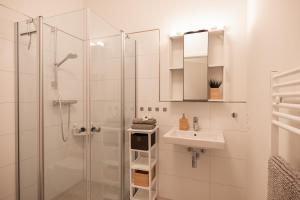 a white bathroom with a sink and a shower at Wohnen am Südstrand - Ferienwohnung 1 5 in Wyk auf Föhr +240 photos