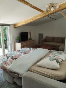 a bedroom with a bed and a couch at Guest house aux portes du Bassin d'Arcachon in Mios