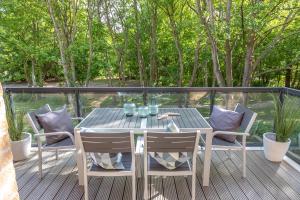 einen Holztisch und Stühle auf einer Terrasse mit Bäumen in der Unterkunft Wohnen am Südstrand - Ferienwohnung 1 7 in Wyk auf Föhr