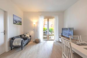 ein Wohnzimmer mit einem Sofa und einem Tisch mit einem TV in der Unterkunft Wohnen am Südstrand - Ferienwohnung 0 1 in Wyk auf Föhr