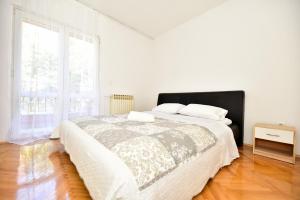 Habitación blanca con cama y ventana en L&L Holiday Apartment, en Zadar