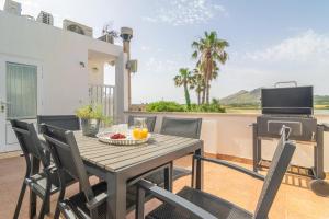 una mesa y sillas en un balcón con parrilla en Sa Fornera, en Alcudia