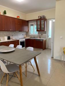 a kitchen with a table and white chairs in it at Comfortable and Modern Holiday Apartment - Alex Apartment II in Daratso