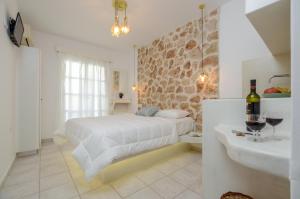 1 dormitorio con 1 cama y baño con lavamanos en simos luxury apartments en Naxos