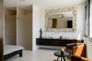 uma casa de banho com um lavatório e um espelho em CHIVA SUN well-being Gästesuite em Brione sopra Minusio