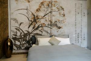 a bedroom with a bed with a painting on the wall at CHIVA SUN well-being Gästesuite in Brione sopra Minusio