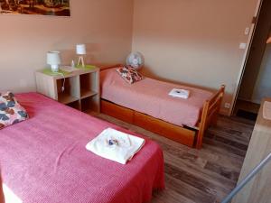 twee bedden in een kleine kamer met rode lakens bij Villa Détente Dauphinoise in Saint-André-le-Gaz