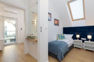 a bedroom with a bed with a blue headboard at Horizon Park Apartment by Renters in Dziwnówek