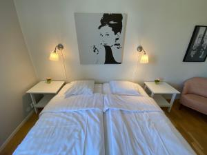 1 dormitorio con 1 cama con sábanas azules y 2 mesas en Hamngatan Logi, en Visby