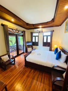 1 dormitorio con 1 cama grande y suelo de madera en Luang Prabang Maison Vongprachan & Travel, en Luang Prabang