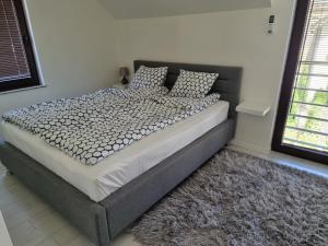 1 dormitorio con 1 cama grande con almohadas y alfombra en Dwie Mewy en Pobierowo