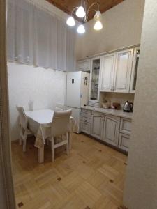a kitchen with a table and a white refrigerator at Квартира у моря в Абхазии Сухум in Sukhum