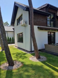 a house with three palm trees in front of it at Dwie Mewy in Pobierowo