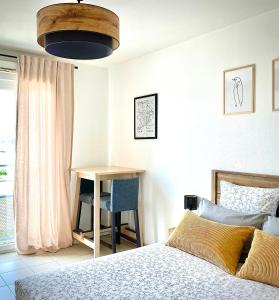 1 dormitorio con cama, mesa y escritorio en Appartement en face Hopital Nord en Saint-Priest-en-Jarez